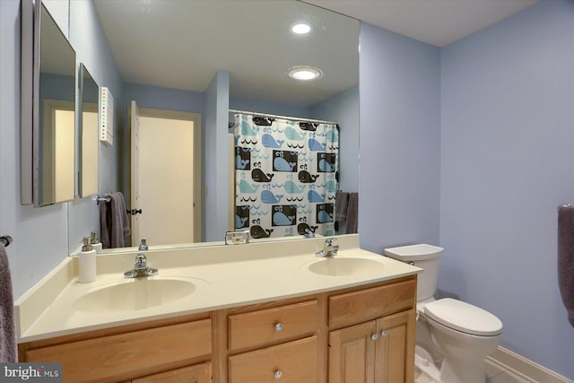 full bath with double vanity, a sink, toilet, and recessed lighting