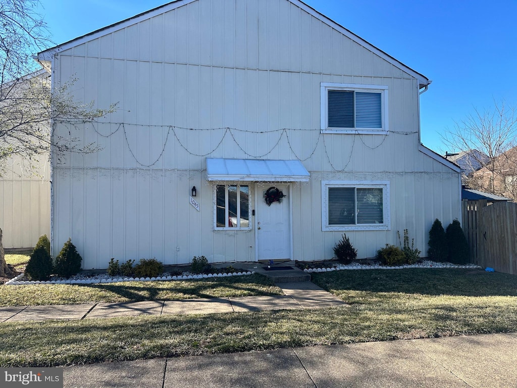 view of front of property featuring fence and a front lawn