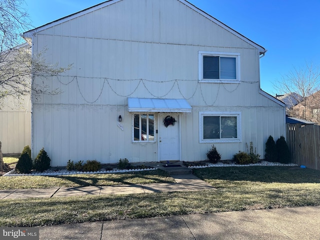 view of front of property featuring fence and a front lawn