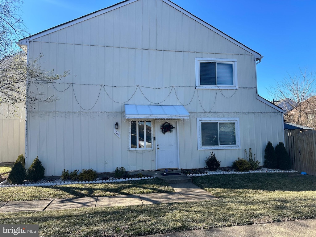 view of front of house featuring fence and a front lawn