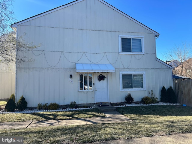 view of front of house featuring fence and a front lawn