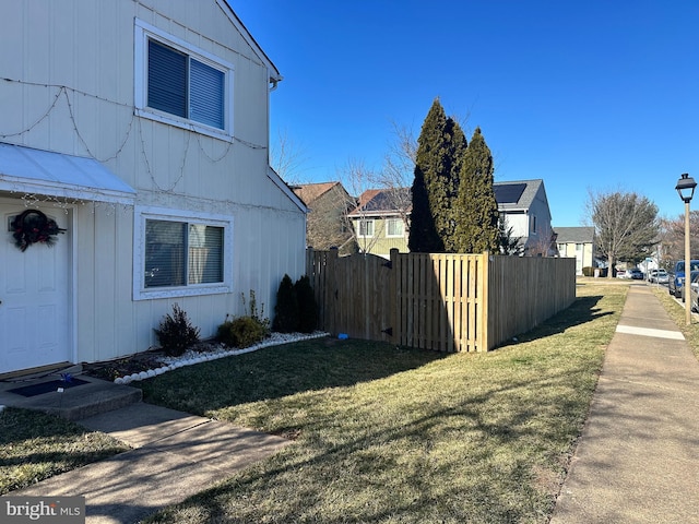 view of side of home featuring a yard and fence