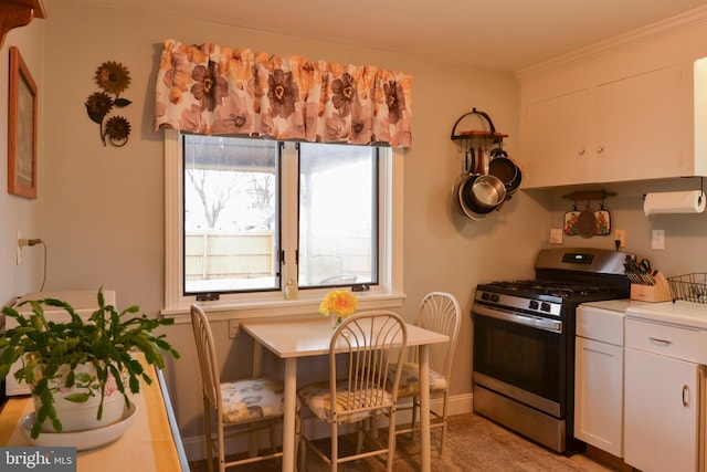 kitchen with light countertops, stainless steel gas range oven, and white cabinetry