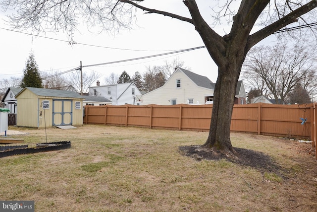 view of yard featuring a fenced backyard, a shed, and an outbuilding