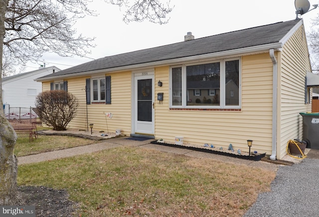 bungalow-style home featuring a chimney and a front lawn