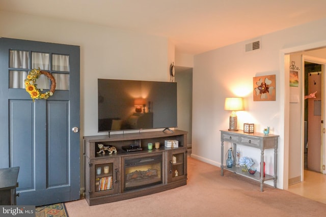 carpeted living area featuring visible vents and baseboards