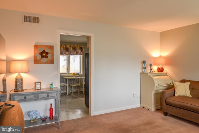 living area with carpet floors, visible vents, and baseboards