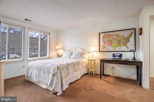 bedroom featuring baseboards, a textured ceiling, visible vents, and carpet flooring