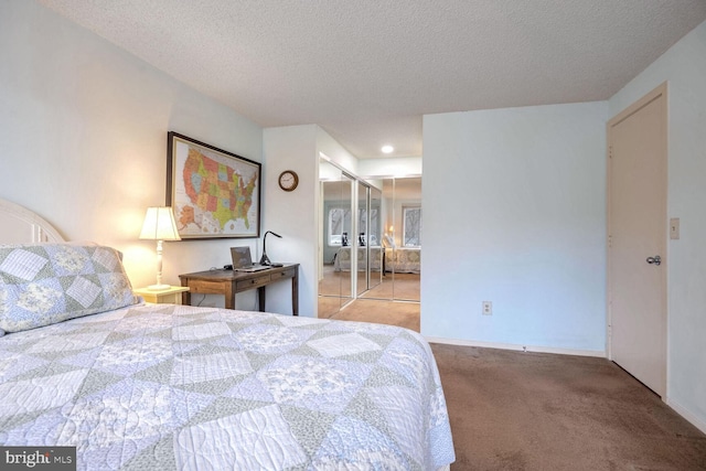 carpeted bedroom with a textured ceiling, a closet, and baseboards