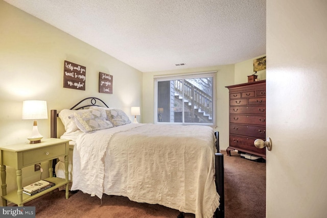 carpeted bedroom featuring visible vents and a textured ceiling