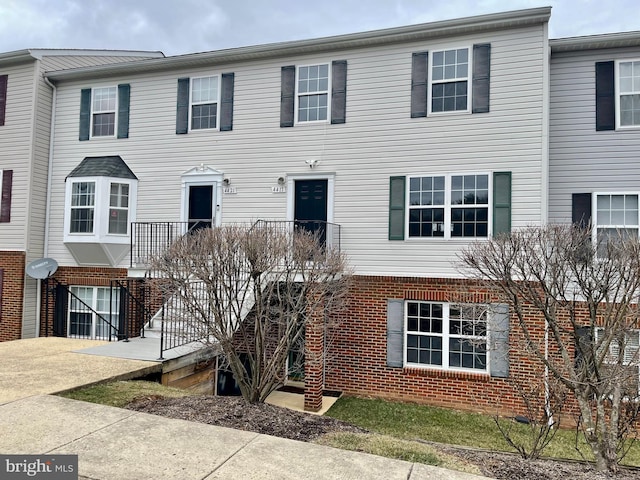 multi unit property featuring stairs and brick siding