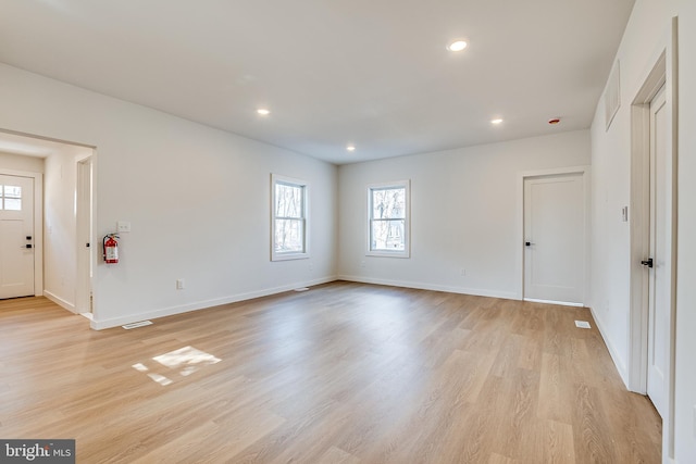 unfurnished room with light wood-type flooring, visible vents, baseboards, and recessed lighting