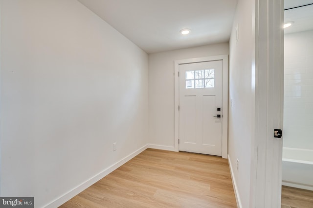 doorway featuring light wood-style flooring and baseboards