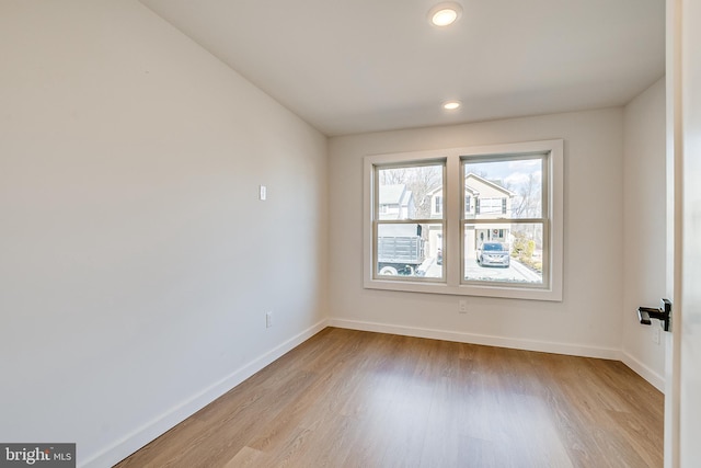 empty room featuring recessed lighting, baseboards, and wood finished floors