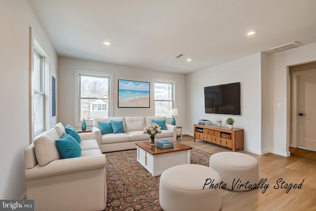 living room with recessed lighting, baseboards, visible vents, and light wood finished floors