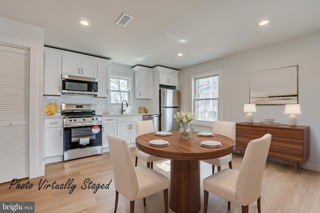 dining room featuring light wood-type flooring, visible vents, and recessed lighting