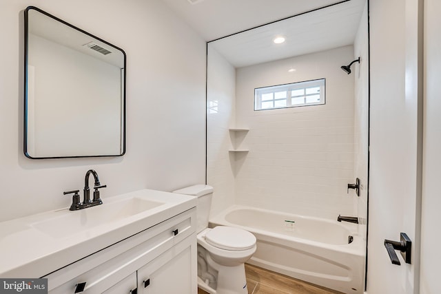 bathroom with toilet, wood finished floors, vanity, visible vents, and shower / bathing tub combination