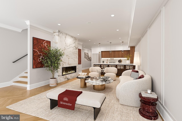 living area featuring recessed lighting, a high end fireplace, baseboards, stairs, and ornamental molding