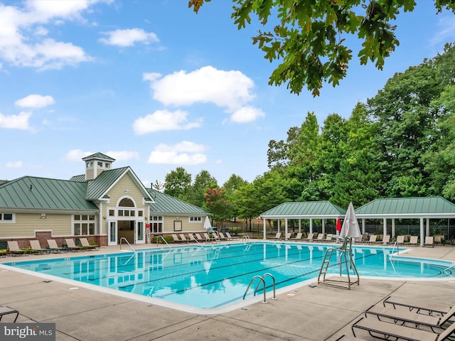 community pool with fence and a patio area