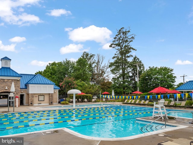 pool with a patio area and fence