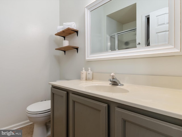 bathroom with vanity, toilet, a stall shower, and tile patterned flooring