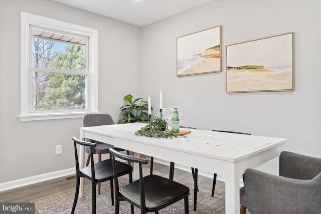 dining room featuring wood finished floors and baseboards