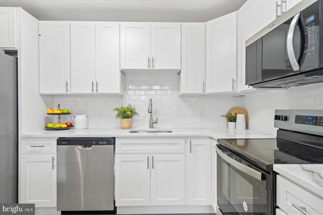 kitchen with appliances with stainless steel finishes, white cabinets, and a sink