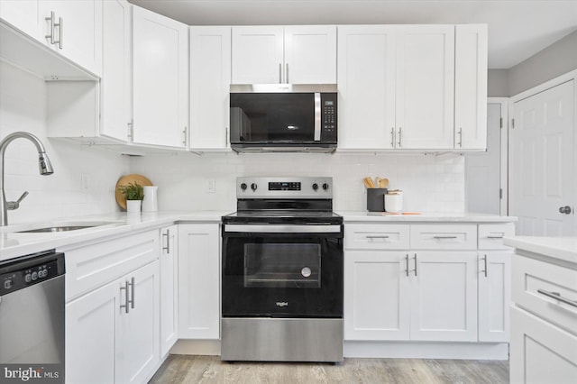 kitchen featuring white cabinets, stainless steel appliances, and a sink