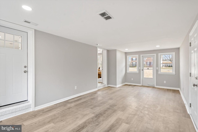 spare room with recessed lighting, visible vents, light wood-style flooring, and baseboards