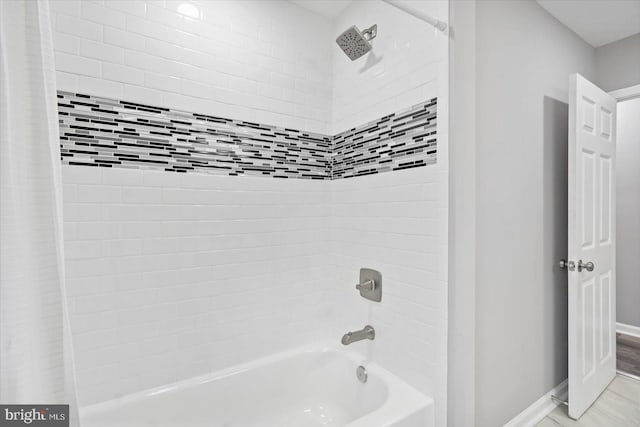 bathroom with baseboards and shower / bath combination with curtain