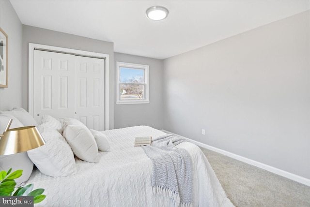 carpeted bedroom with a closet and baseboards