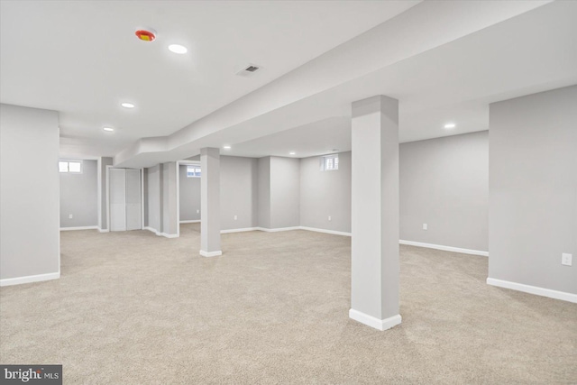 below grade area with baseboards, light colored carpet, and recessed lighting