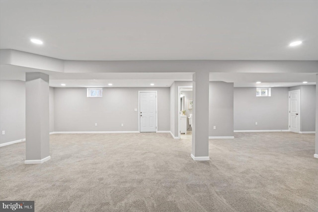 basement featuring baseboards, light colored carpet, and recessed lighting