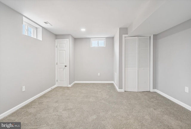 below grade area with carpet, visible vents, and baseboards