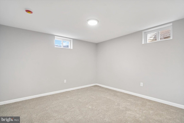 below grade area featuring carpet, plenty of natural light, and baseboards