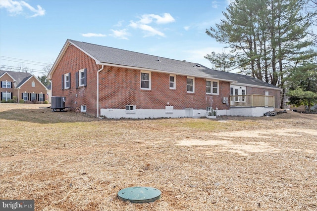 back of property with cooling unit and brick siding