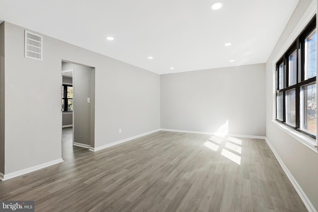 spare room with visible vents, baseboards, and wood finished floors