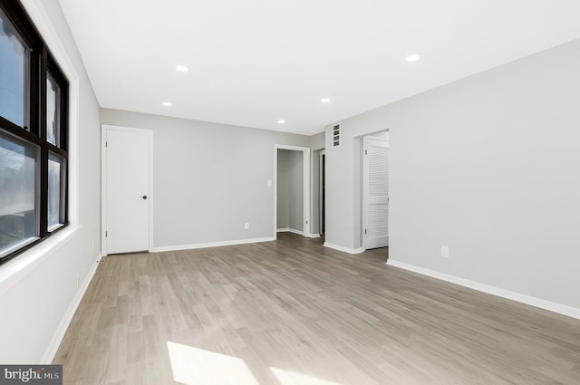 unfurnished room featuring light wood-type flooring, baseboards, and recessed lighting