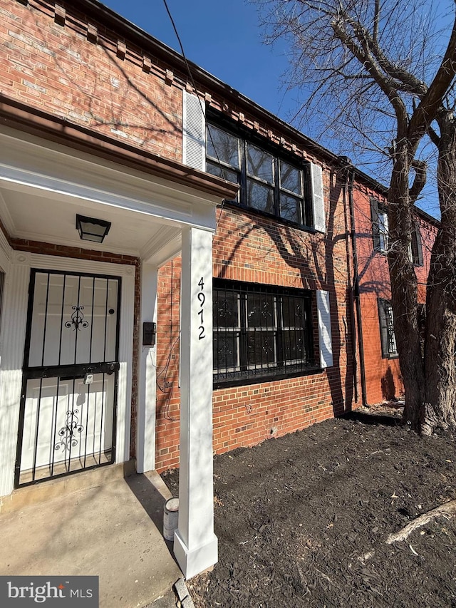 doorway to property featuring brick siding