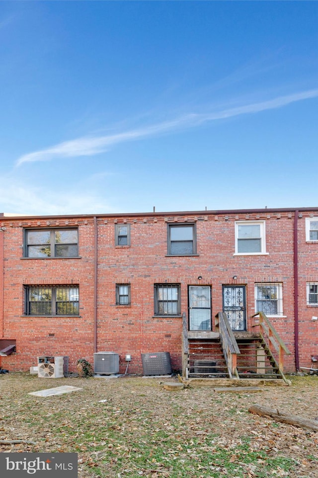 view of front of property featuring brick siding and cooling unit