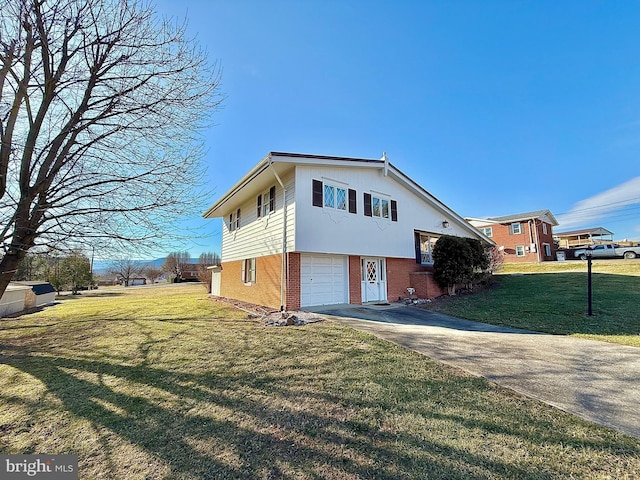 view of side of property with brick siding, a lawn, an attached garage, and concrete driveway