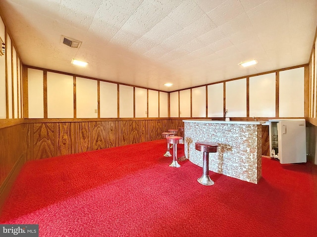 interior space with a wainscoted wall, recessed lighting, carpet, and visible vents