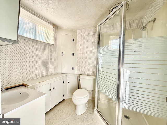 full bath featuring toilet, a stall shower, a textured ceiling, and vanity