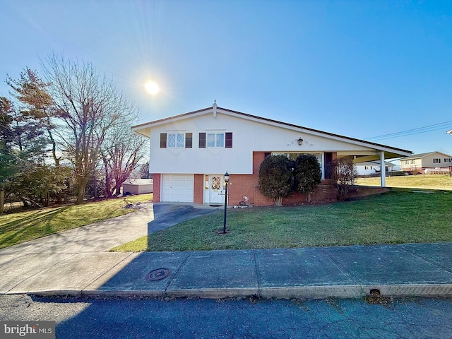 view of front of property with driveway, brick siding, an attached garage, and a front lawn