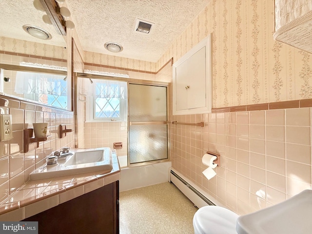 full bath with visible vents, a textured ceiling, wainscoting, wallpapered walls, and baseboard heating