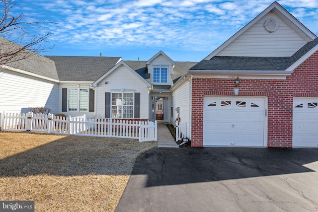 view of front of house featuring a garage, brick siding, fence, driveway, and roof with shingles