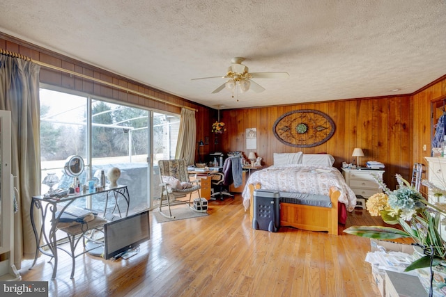 bedroom featuring hardwood / wood-style floors, access to exterior, crown molding, and a textured ceiling