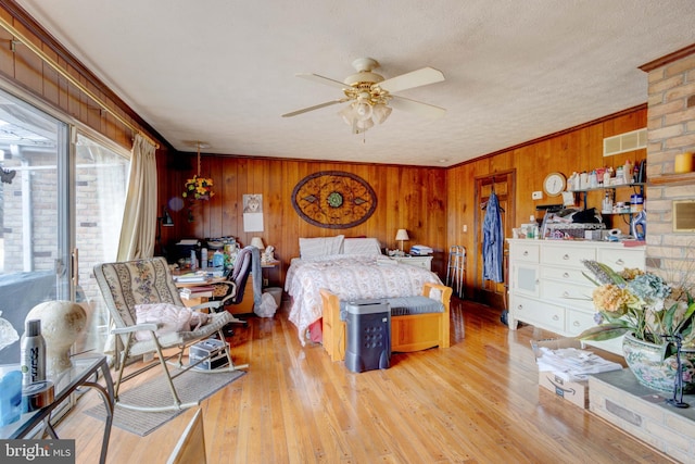 bedroom featuring visible vents, light wood-style flooring, and ornamental molding