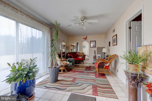 sitting room featuring light tile patterned floors, a healthy amount of sunlight, visible vents, and arched walkways