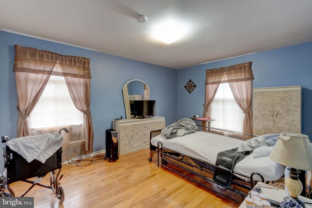 bedroom featuring multiple windows and wood finished floors